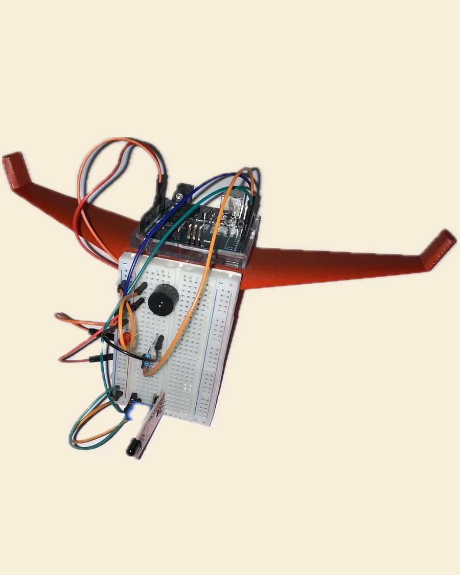 The IGNIS prototype: a terracotta 3D-printed flying-wing airframe with a breadboard and an Arduino Uno wired to a buzzer, LED and sensors mounted on top