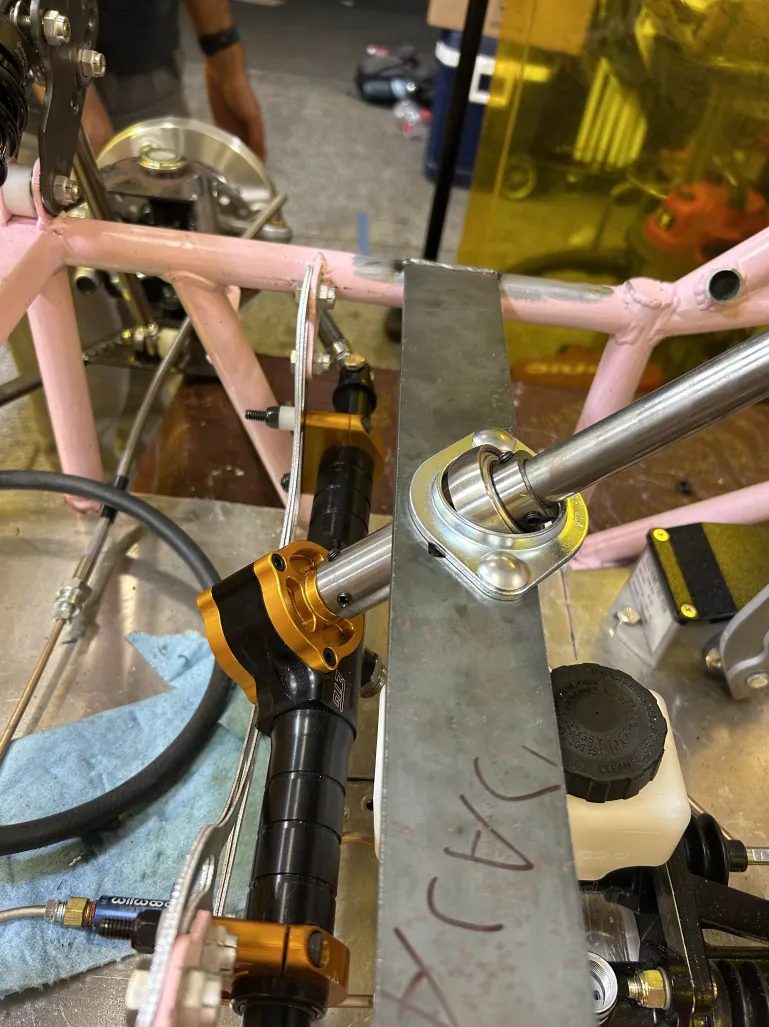 An early flange-bearing support for the steering column, mounted on the chassis near the brake reservoir
