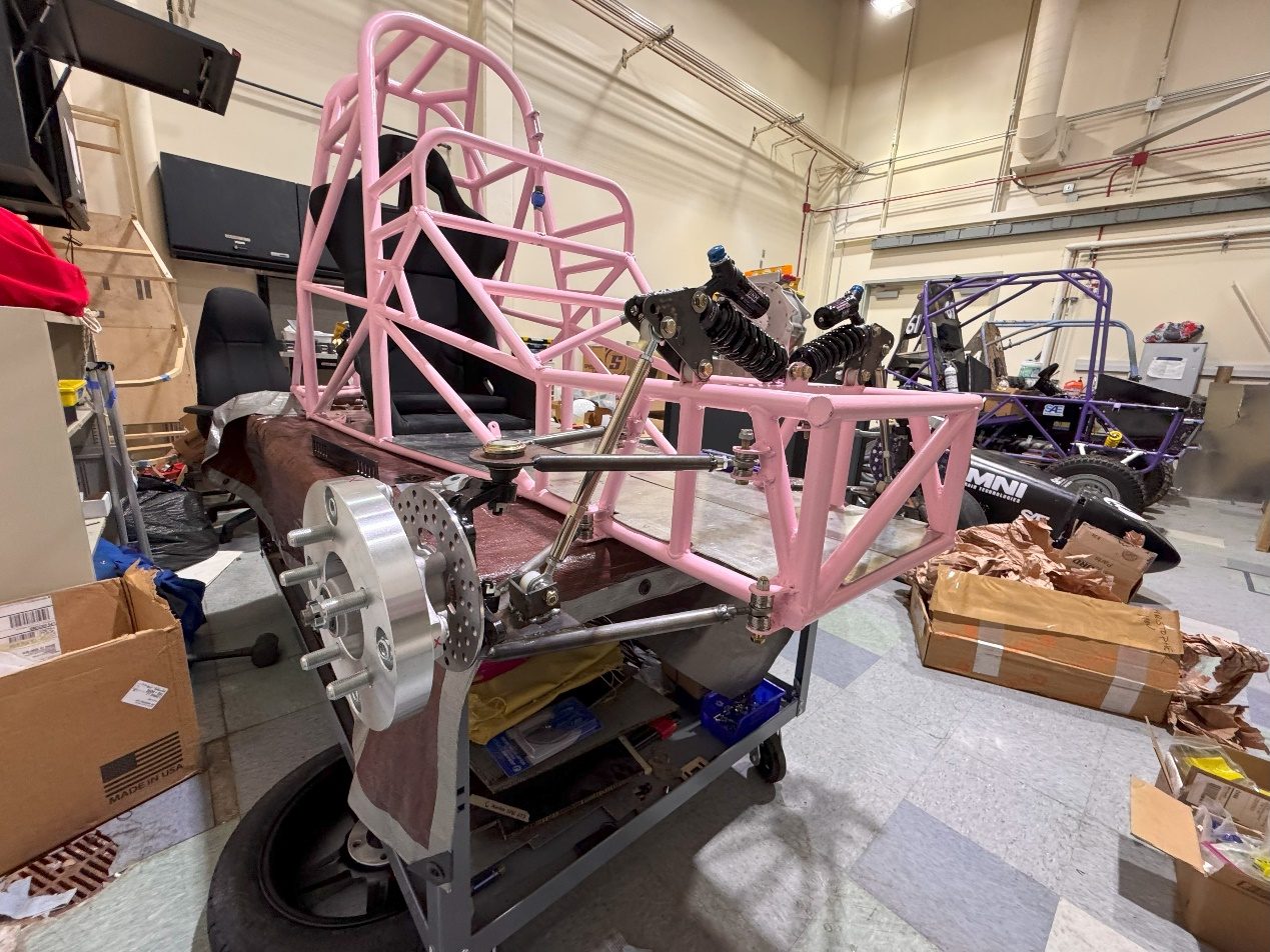 The chassis with the front and rear suspension assembled, still up on a stand