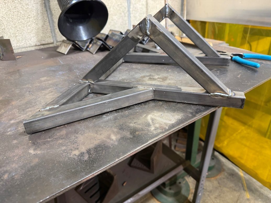 The freshly welded bare-metal trailing arm